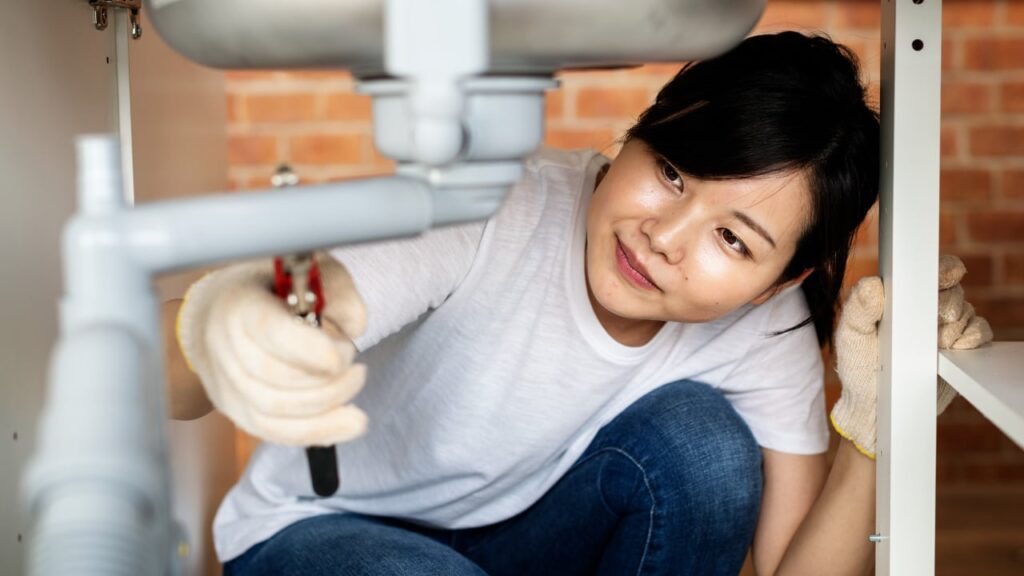 woman working on plumbing